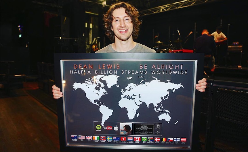 Dean Lewis holding a plaque for his 2018 single 'Be Alright' reaching half a billion streams worldwide