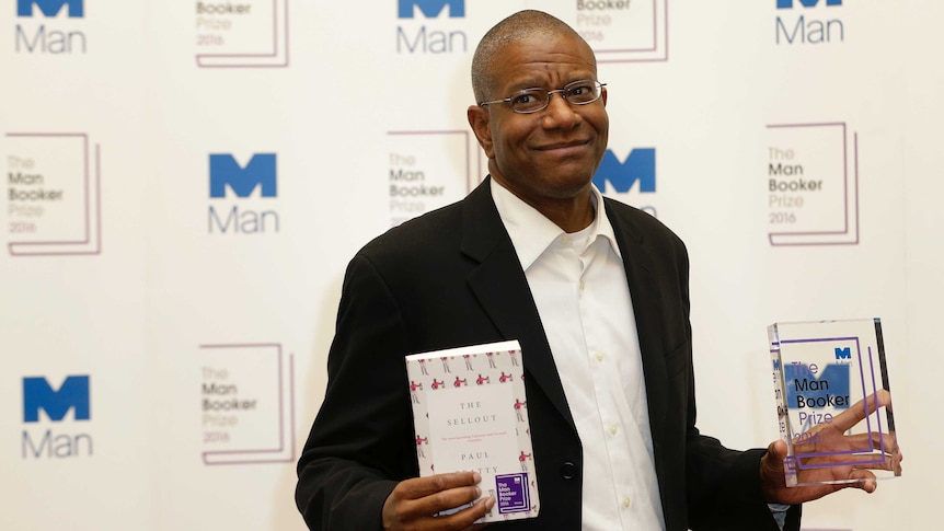 Paul Beatty poses with his book The Sellout and and statuette after hi Man Booker Prize win