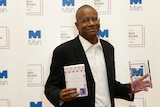 Paul Beatty poses with his book The Sellout and and statuette after hi Man Booker Prize win
