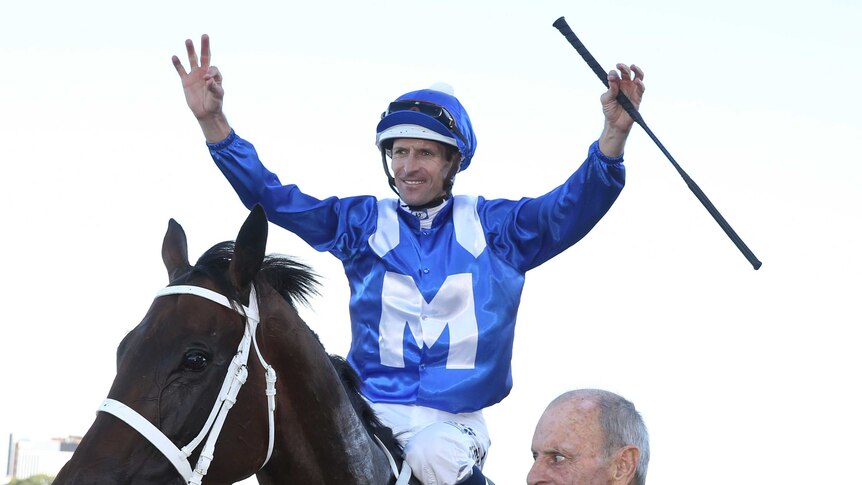 Hugh Bowman raises his arms in victory atop Winx