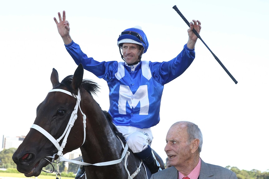 Hugh Bowman raises his arms in victory atop Winx