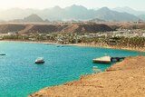 A beach town in Egypt with blue water and desert backdrop.
