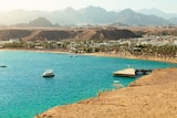 A beach town in Egypt with blue water and desert backdrop.