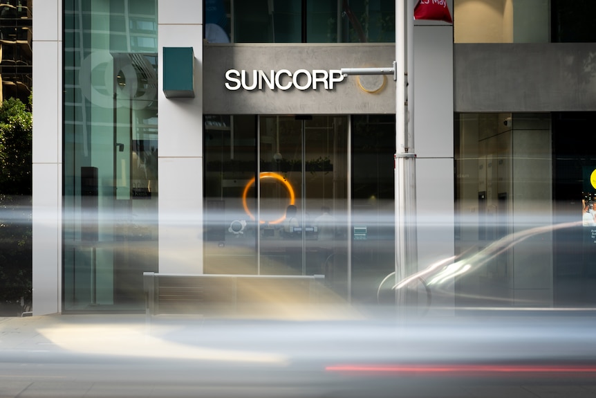 Cars drive past the front of a Suncorp Bank branch in the city.