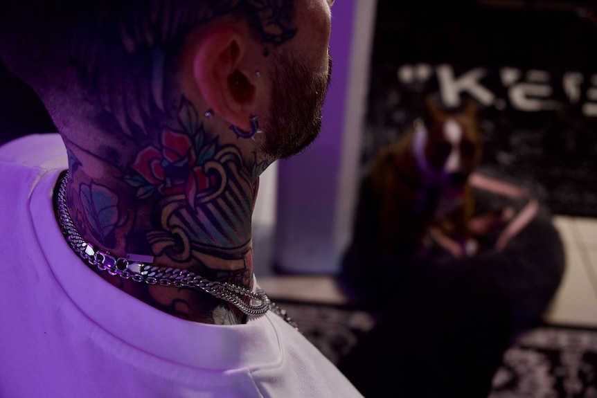A close up of a rose tattoo on a man's neck