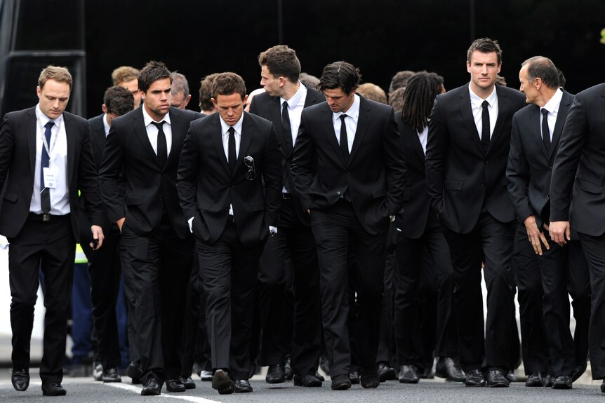 Collingwood players arrive at the funeral of John McCarthy.