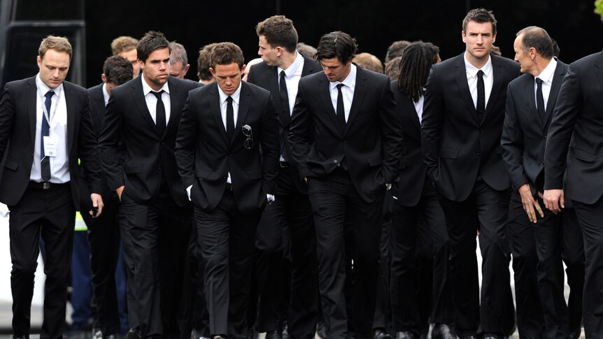 Collingwood players arrive at the funeral of John McCarthy.