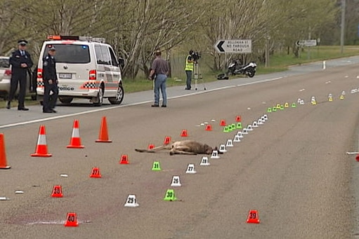 Police examine the scene of the fatal accident on the Barton Highway.