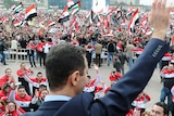 Assad waves to supporters