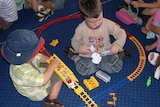 Two boys playing with trains on floor at child care centre, Canberra