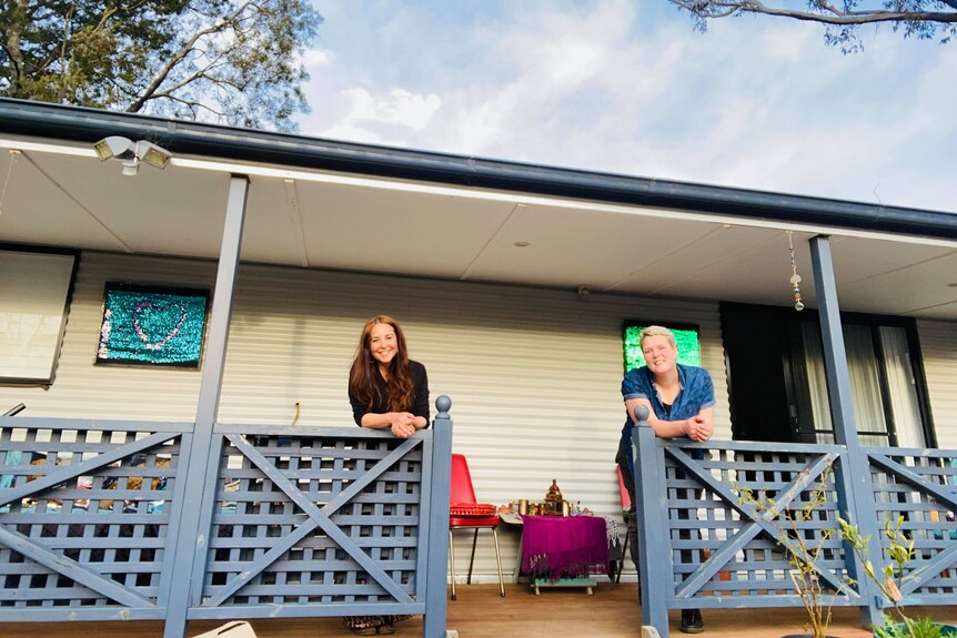 Two women standing on a verandah for a story on home ownership.