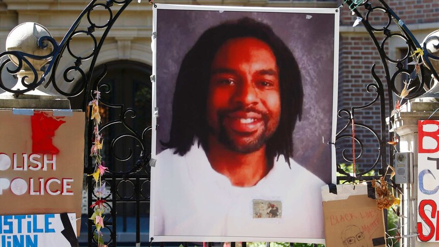 A memorial including a photo of Philando Castile adorns the gate to the governor's residence.