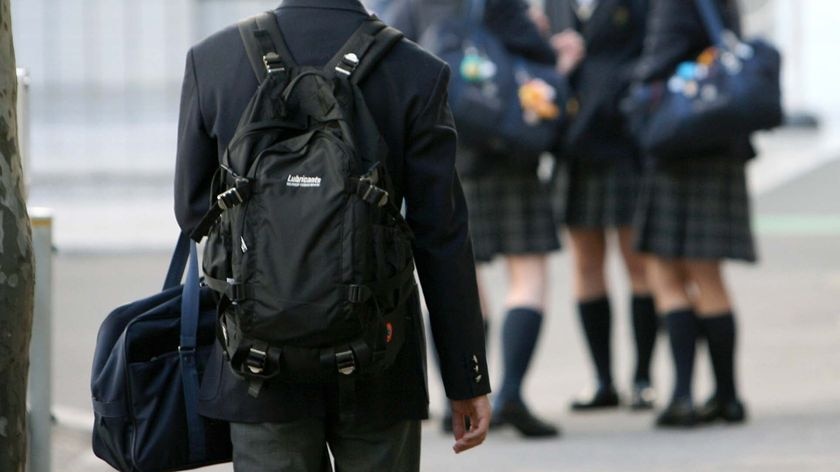 A high school student walks towards a group of female students (Reuters: Kiyoshi Ota)