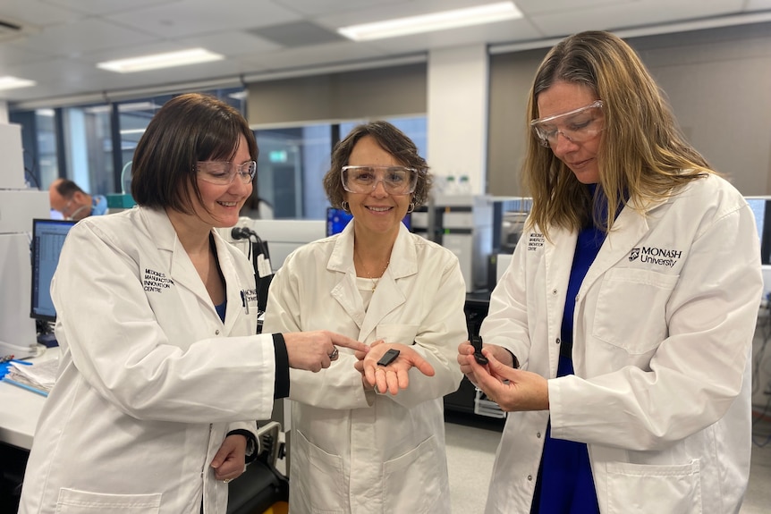Three women in white lab coats.
