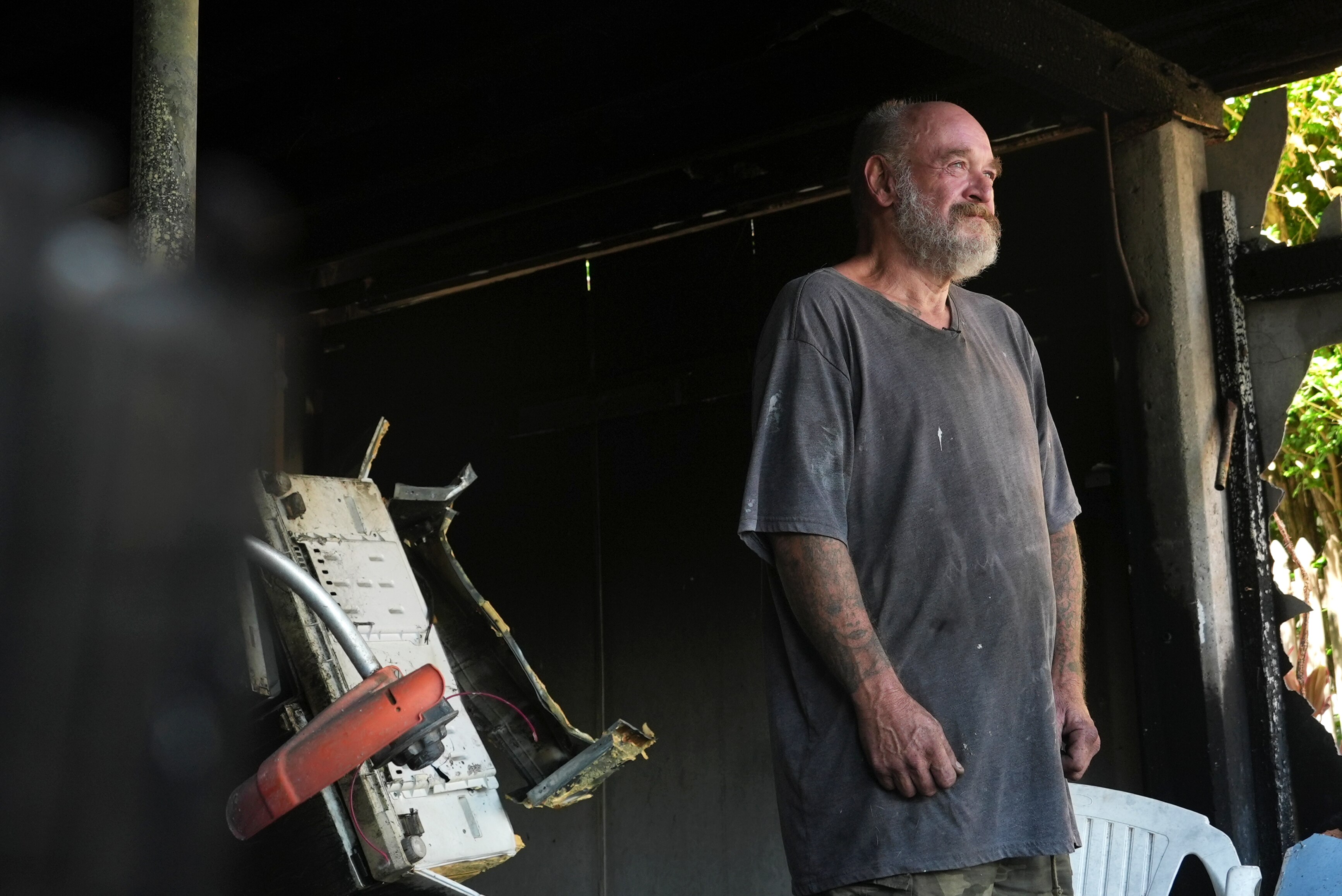 A man standing in the burnt remains of a house