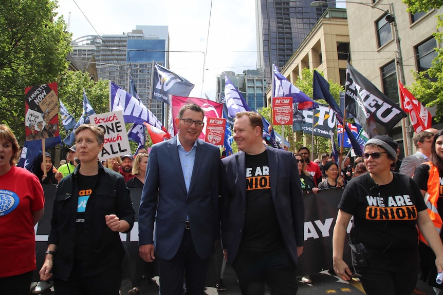 The three leaders at the front of the rally, with flags waving behind them.