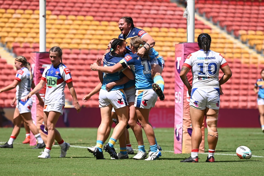 A group of rugby league players celebrate a victory 