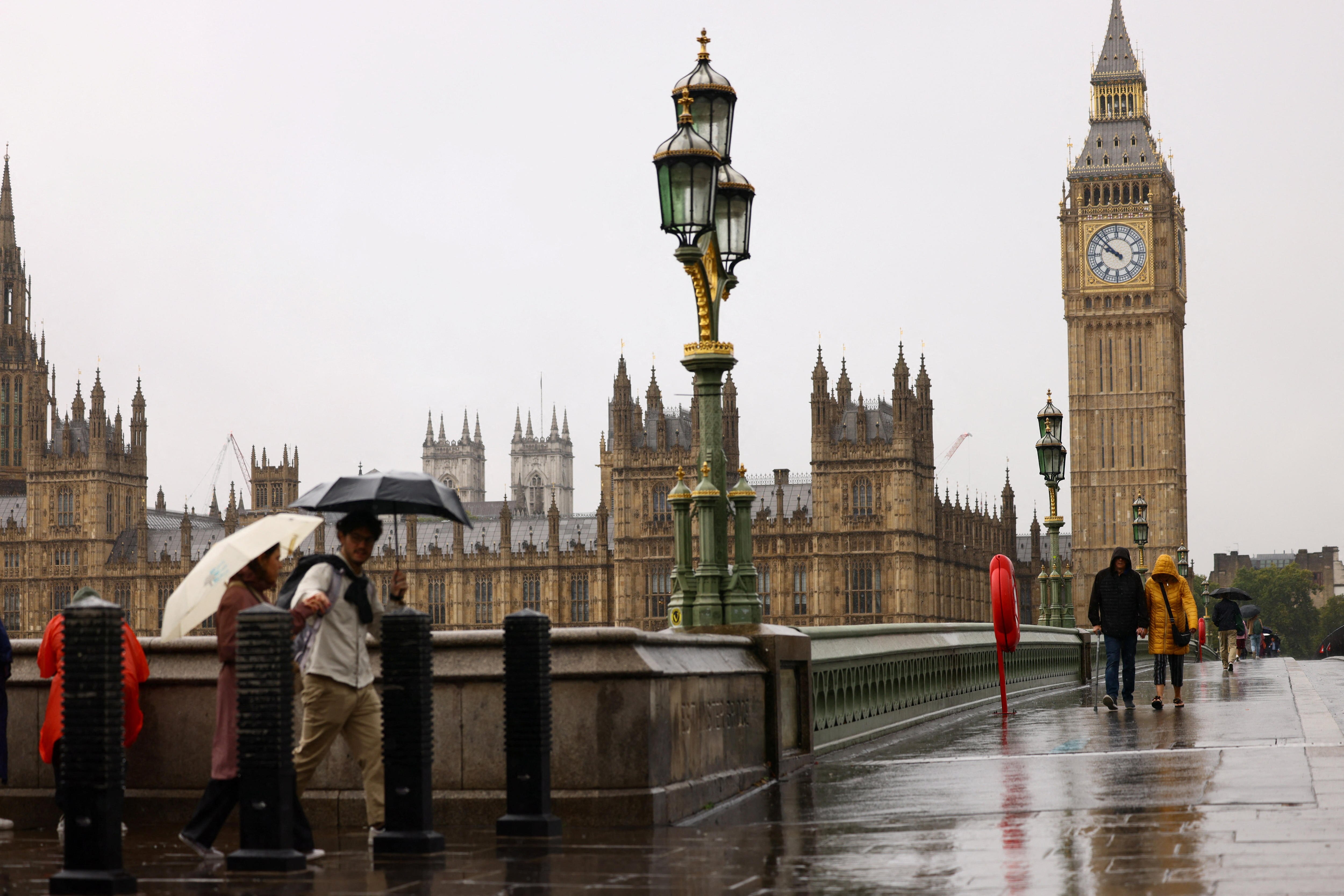 The UK Houses of Parliament on a rainy day, seen from the other side of the River Thames.