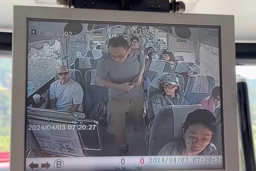 An image of a small screen playing a video of a man walking off a bus