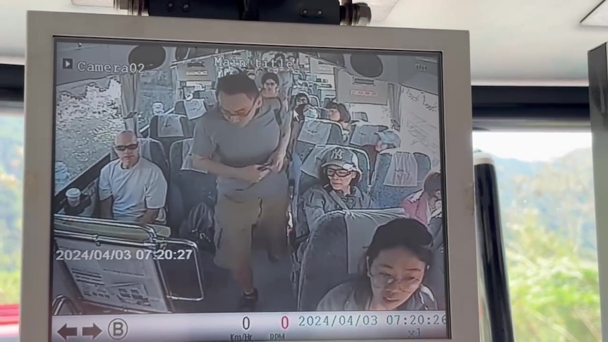 An image of a small screen playing a video of a man walking off a bus