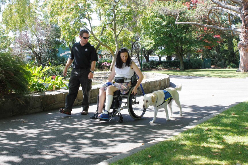 Ken Innes and Natasha Street with assistance dog Biscuit in Launceston
