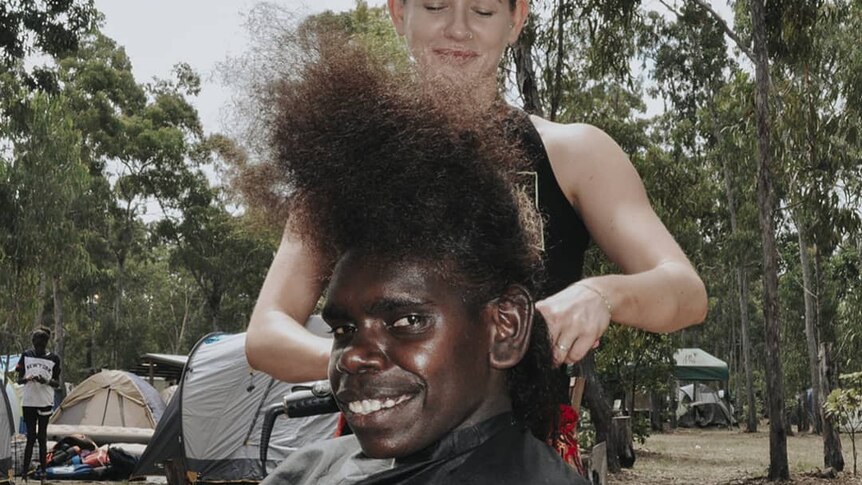 An indigenous person is having their hair styled.