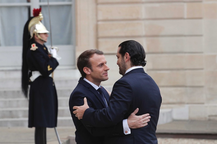 French President Emmanuel Macron, left, embraces Lebanon's Prime Minister Saad Hariri
