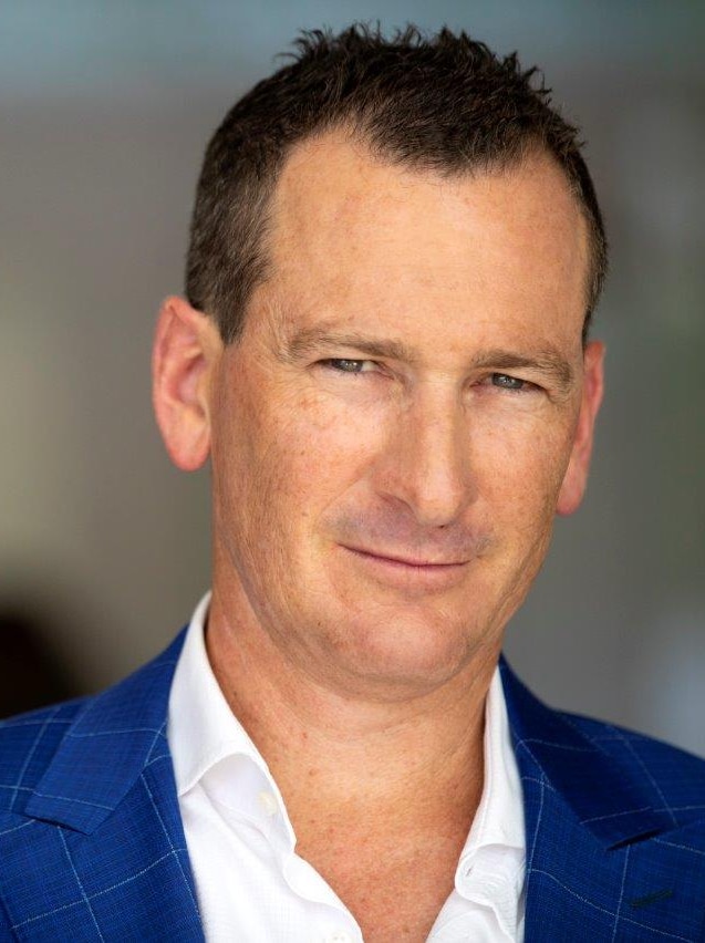 Headshot of man in suit and jacket.