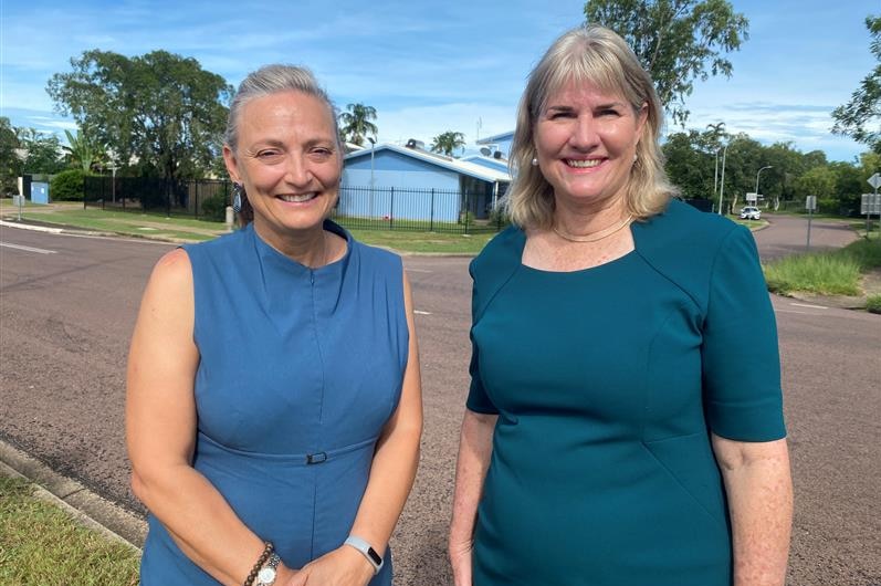 Two female politicians outside a housing block.