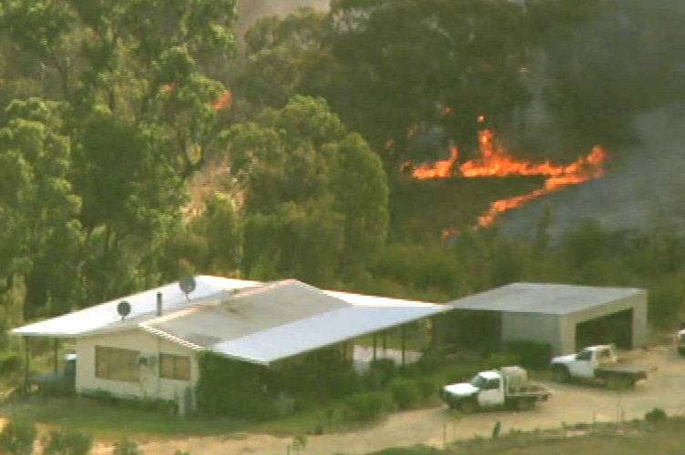 Flames are in trees about 30 metres from a home.