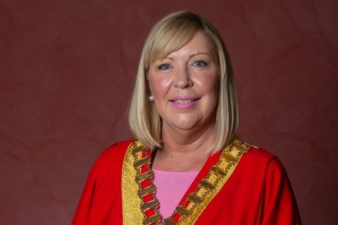 A portrait photo of a woman in mayoral robes.