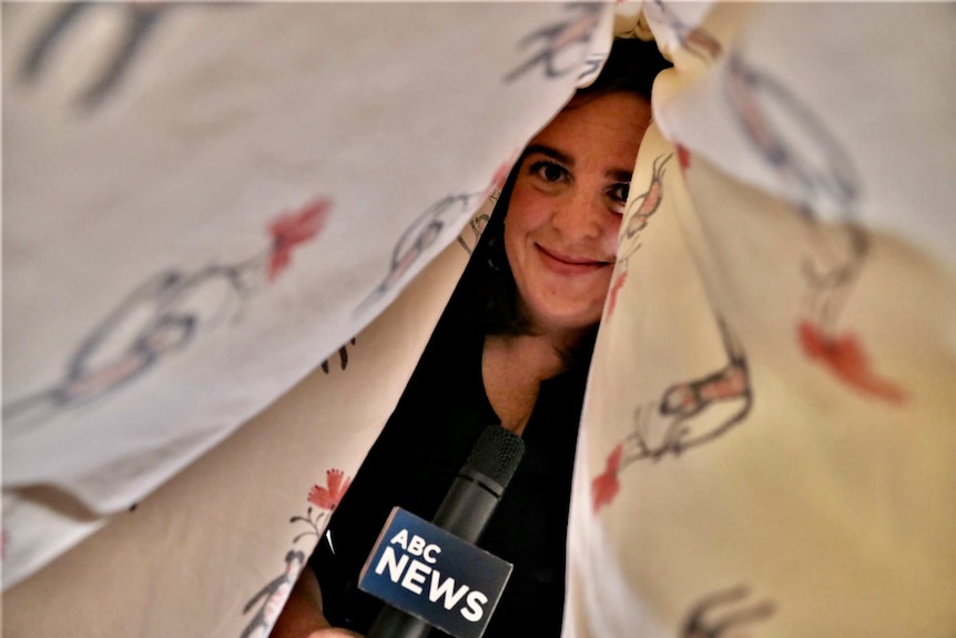 Henderson holding ABC microphone under doona.