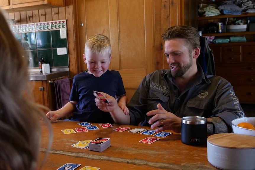 A son and dad playing Uno.