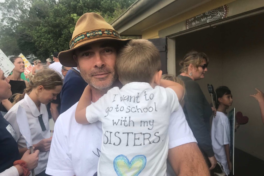 A father and son protest the enrolment cap at Coorabell Public School.