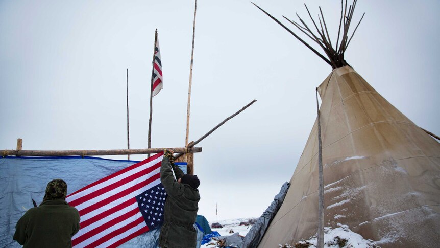 Protesters hang a flag at the Oceti Sakowin camp