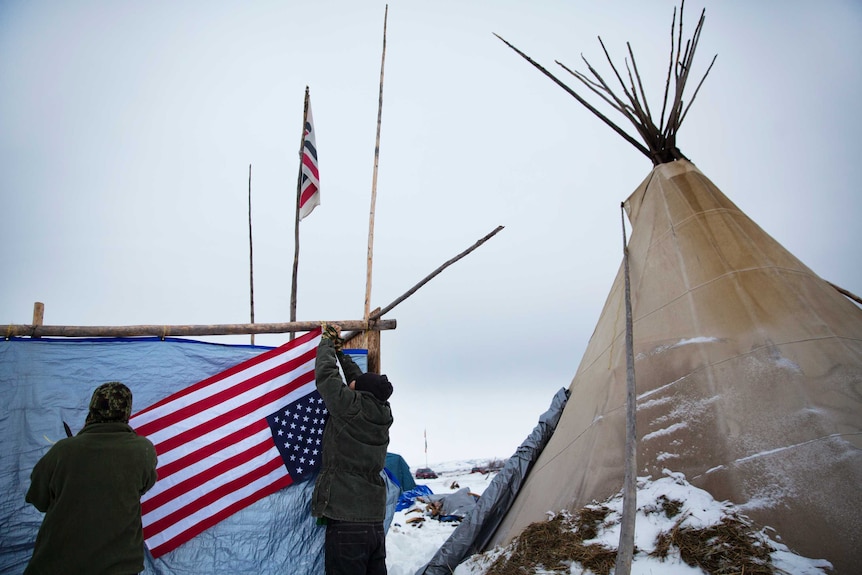 Protesters hang a flag at the Oceti Sakowin camp