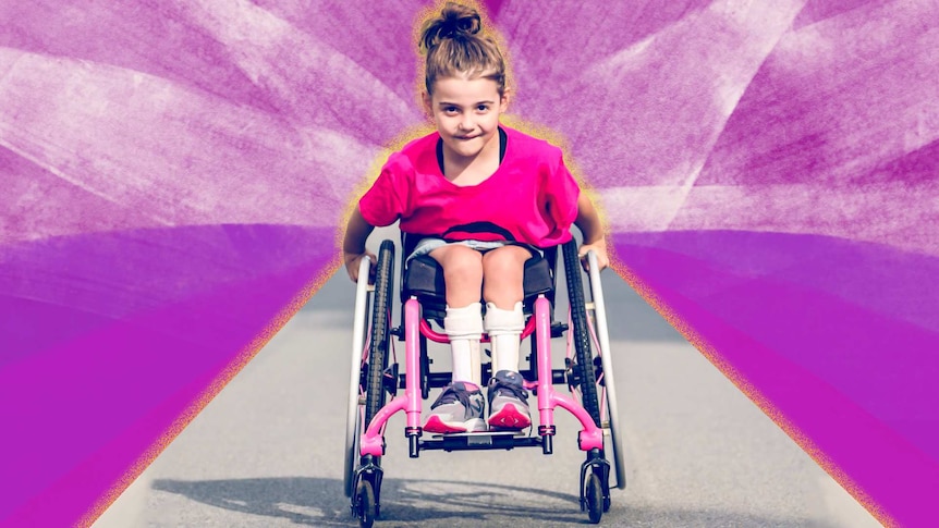 A young girl in a wheelchair looks straight at the camera.