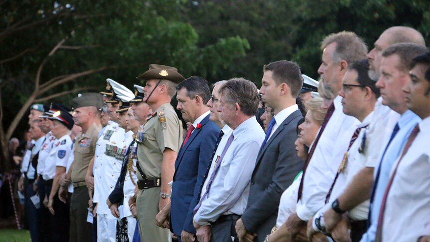People, Chief Minister Michael Gunner and other politicians, stand in a row at the dawn service.