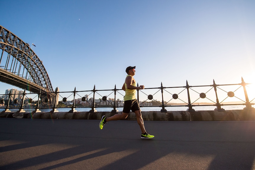 A man running past the Sydney Harbour Bridge