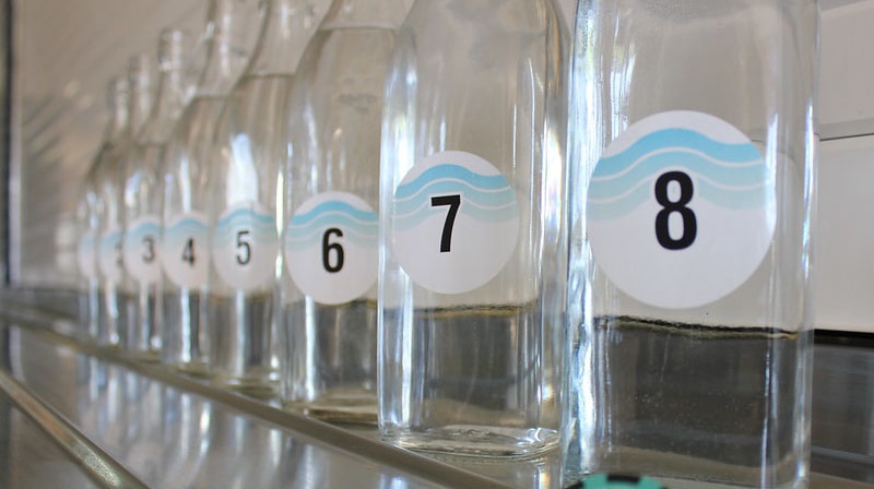 Numbered bottles of water from one to eight  lined up in a row.