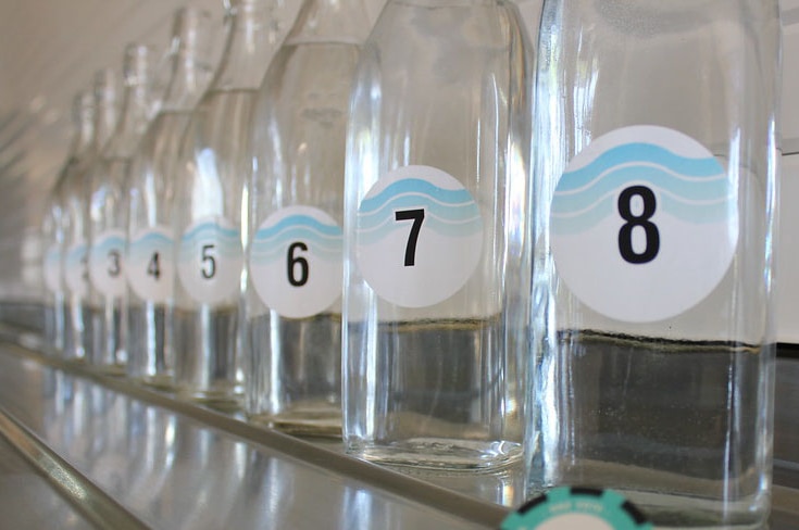 Numbered bottles of water from one to eight  lined up in a row.