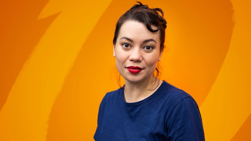 Actor Catherine Van-Davies in front of an orange wall and black curtain.