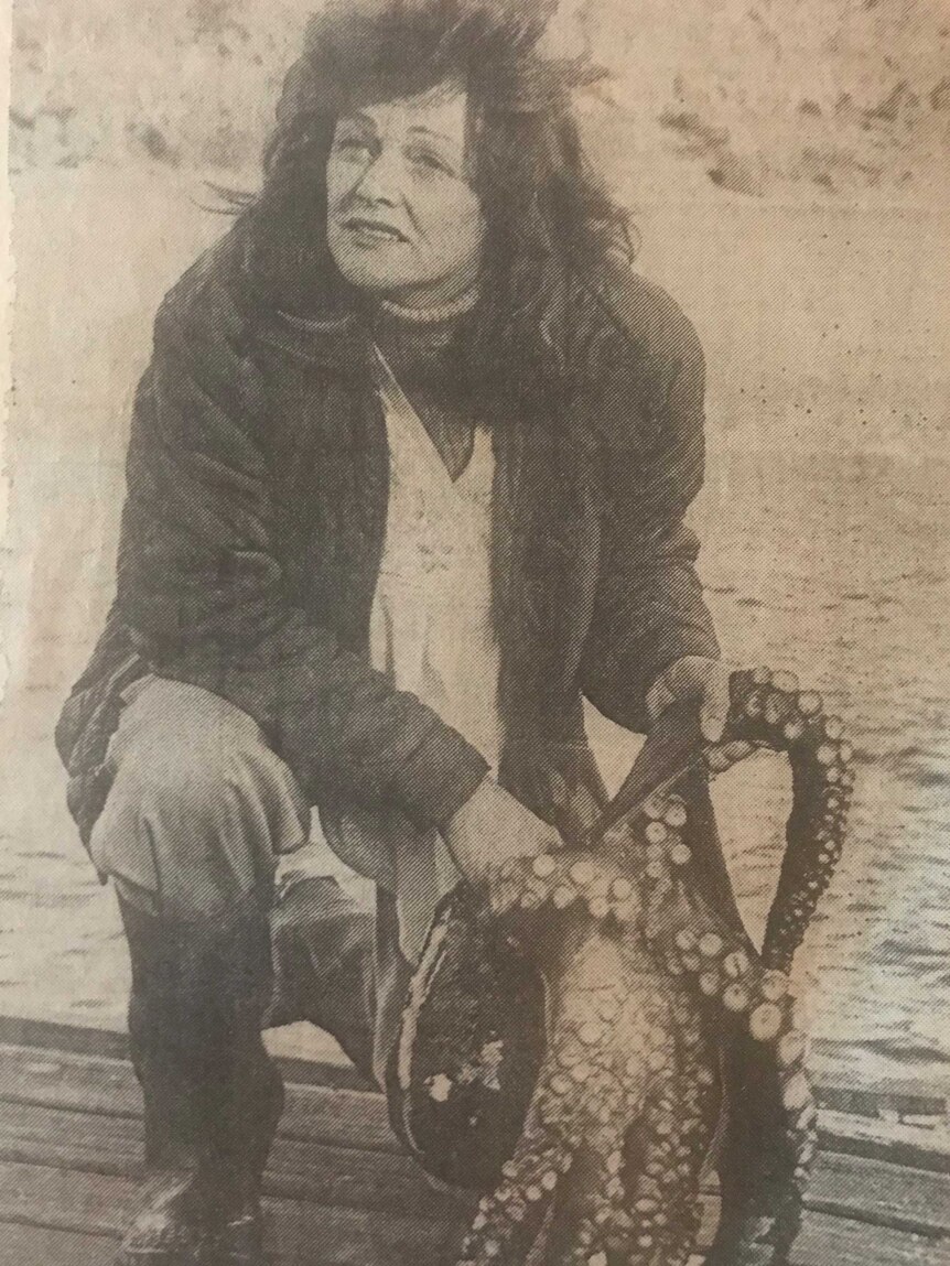 Rosalie Schwertfeger holds an octopus on the beach.