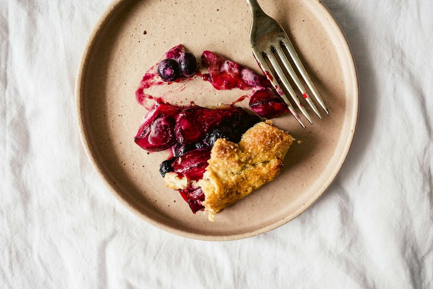 A slice of summer galette with stone fruit and blueberries on a plate, an easy dessert recipe.