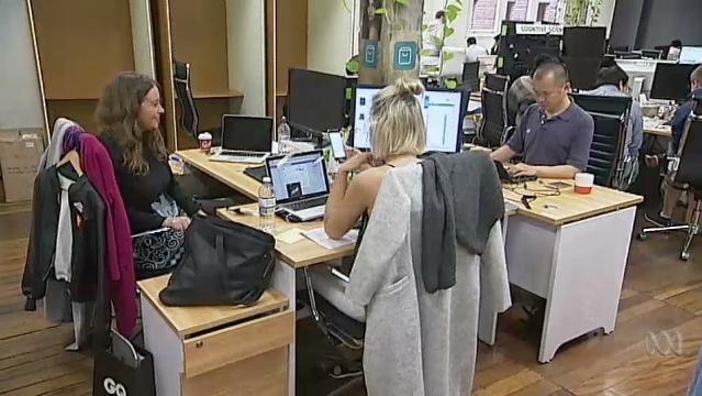 People sit at computers in an office space
