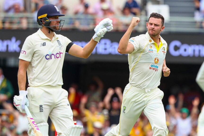 Australia bowler Josh Hazlewood clenches his fist as he runs past England batter Dawid Malan during the Ashes.