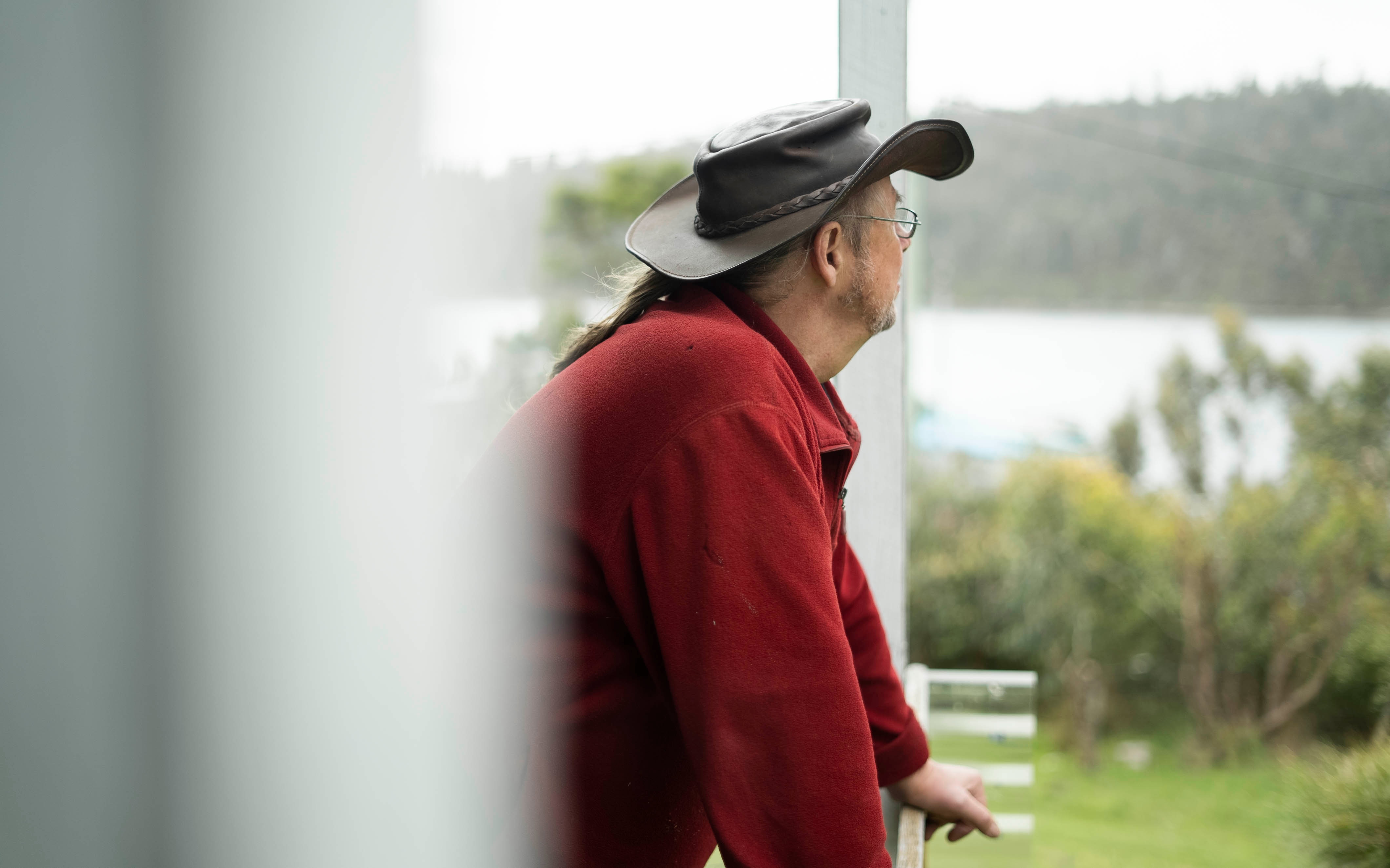 Malcolm Battersby looks out to the water from the deck at his home.