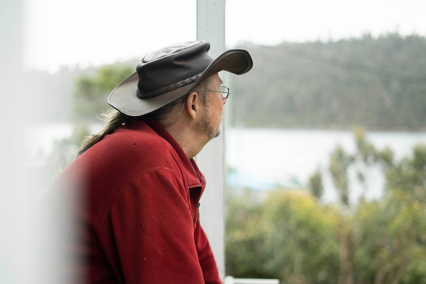 Malcolm Battersby looks out to the water from the deck at his home.
