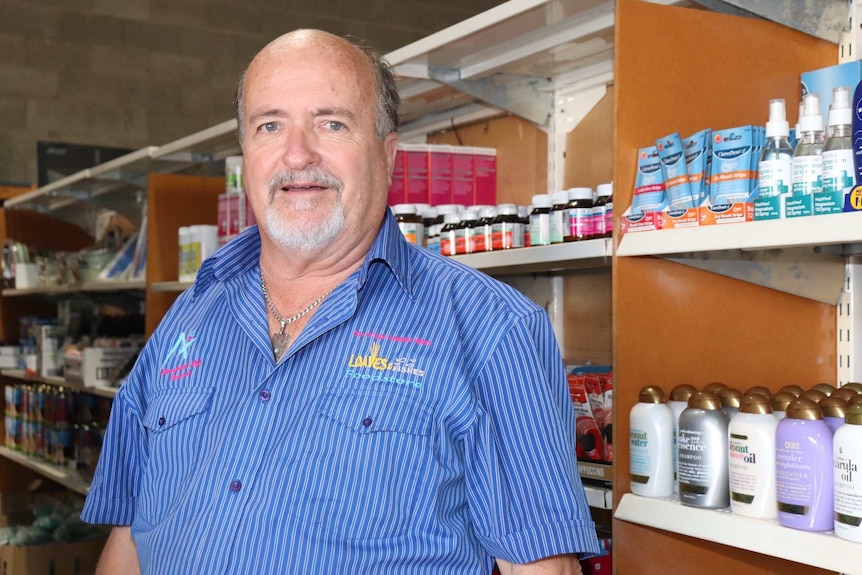 A man stands in the aisles of a supermarket.