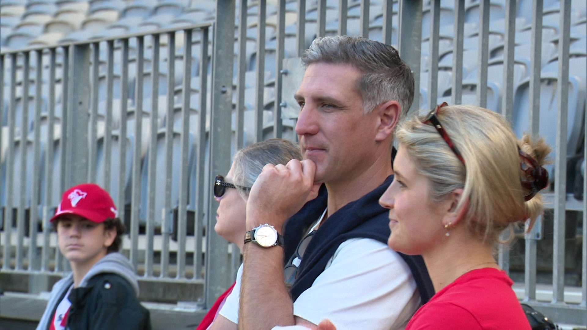 Matthew Pavlich watches a football club train with a blonde woman to his left and two more people to his right. 